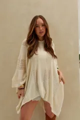 Poncho de tejido de punto color crudo, con capucha y diseño amplio.