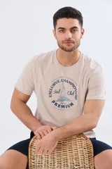 Remera azul marino de manga corta con cuello redondo, confeccionada en mezcla de algodón y poliéster. Presenta un estampado frontal circular de inspiración vintage con diseño de velero y tipografía alusiva a clubes deportivos.
