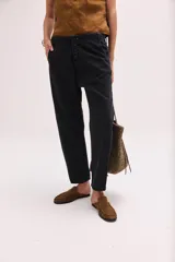 Pantalón de denim celeste de tiro bajo, con calce relajado y cierre frontal de múltiples botones metálicos visibles.