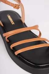 Sandalias plateadas de símil cuero con tiras finas entrelazadas y plataforma negra. Cuentan con una pequeña hebilla en el tobillo para ajustar a tu comodidad.