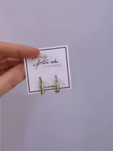 Aros de acero quirúrgico dorado en forma de argolla con incrustaciones de strass en el frente.