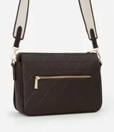 Bolso tipo bandolera de color marrón oscuro, con textura de cuero sintético (PU) y patrón geométrico acolchado en la parte frontal. Cuenta con herrajes dorados, cierre superior y una correa ancha de tela bicolor (beige y marrón) ajustable.