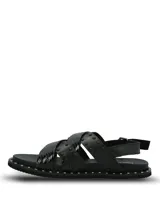 Sandalias negras de cuero con diseño de tiras cruzadas, decoradas con tachas metálicas. Poseen ajuste mediante hebilla lateral y suela de goma con detalle de tachas en el borde.