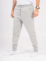 Pantalón de jogging gris melange, corte babucha, con cintura elástica ajustable con cordón y puños en los tobillos. Confeccionado en tejido de punto sin felpa.