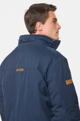 Campera color marrón con capucha desmontable, cierre frontal con cremallera y botones a presión, múltiples bolsillos con solapa y puños ajustables con botones.