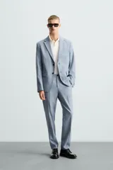 Blazer de corte slim fit confeccionada en tejido con lana, con cuello de solapas de muesca, cierre frontal de un botón, bolsillos laterales con solapa y bolsillo de vivo en el pecho.