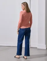 Cardigan blanco de tejido fino con abertura central y botones.