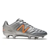 Championes de fútbol New Balance 442 V2 Pro FG color plateado con detalles en naranja.