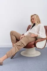 Pantalon de corderoy color beige, de corte holgado tipo cargo, con bolsillos laterales aplicados, cintura elástica y puños elásticos en los tobillos.