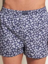 Bóxer de algodón azul marino con estampado de pequeñas flores blancas y grises, cintura elástica con etiqueta de la marca.