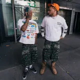 Short cargo tipo baggy con estampado camuflado. Presenta detalles de roturas, bolsillos laterales tipo cargo y tiras ajustables en el ruedo. Incluye bordado con el nombre de la marca en la parte frontal.