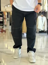Pantalón cargo de jean azul con múltiples bolsillos en los laterales y diseño holgado.