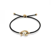 Pulsera de hilo negro ajustable con dije central de perla shell y fornitura bañada en oro de 18k.