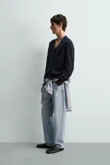 Cárdigan de punto relaxed fit confeccionado en mezcla de algodón y lino, en color azul marino. Presenta cuello en V, manga larga, bolsillos delanteros de plastrón, acabados en rib y cierre frontal con botones.