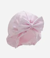 Gorro turbante de satén color rosa con diseño estampado sutil y detalle de moño grande al frente.