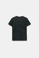 Remera negra de efecto lavado con corte slim fit, cuello redondo y manga corta. Cuenta con un estampado frontal con la frase "100% ICONIC" hecha con aplicaciones de brillos plateados.