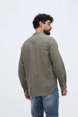 Camisa de lino y algodón color celeste, con cuello mao, cierre frontal de botones claros y pequeño bordado de pato en el pecho.