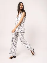 Pantalón de lino estampado con flores azules, de tiro alto y corte palazzo, con elástico en la pretina trasera, cierre delantero y broche interno. Tiene bolsillos laterales, dobladillo invisible y tajos a los costados.