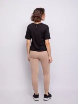 Pantalón tipo babucha de corte deportivo, color beige, con cintura elástica ajustable mediante cordón, puños en los tobillos y bolsillos frontales.