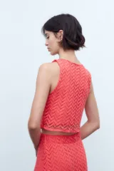 Blusa de encaje coral sin mangas.