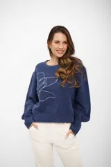 Buzo de tejido de punto azul oscuro con cuello redondo y un diseño lineal de una flor en blanco en el frente.