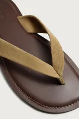Sandalias planas de cuero para hombre, con suela marrón oscuro y tiras anchas en el empeine de ante en color tostado.
