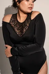 Body negro de lycra con mangas largas y escote alto de puntilla con aberturas en los hombros.