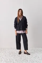 Sobrecamisa de jean azul oscuro, de calce relajado, escote en V, bolsillos delanteros aplicados, cierre frontal con botones metálicos y pespuntes en contraste.