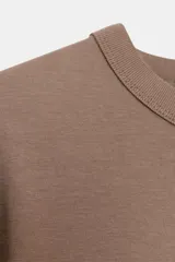 Camiseta de manga larga confeccionada en tejido de punto interlock elástico y flexible, con cuello redondo y bajo recto.