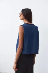 Chaleco azul de denim con ribete negro.