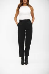 Pantalón negro de vestir, tiro alto, con pinzas frontales y corte recto y holgado que termina por encima del tobillo. Posee trabillas para cinturón y bolsillos laterales.