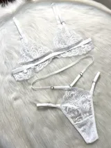 Conjunto de lencería de cuatro piezas en color blanco, confeccionado en encaje con diseño floral. Incluye bralette triangular, tanga de tiro alto con tiras ajustables, portaligas integrado y ligas para las piernas.