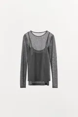 Camiseta de manga larga color beige, con cuello redondo y detalle de camiseta interior en el mismo tejido. Tiene un bajo asimétrico y corte slim fit.