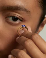Anillo de plata bañada en oro con piedra azul facetada en forma de ojo de gato.