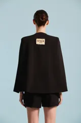 Capa de mujer color negro, con diseño envolvente y silueta estructurada, confeccionada por Karech para ocasiones especiales.