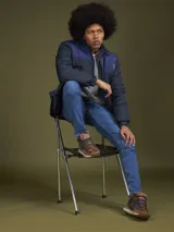 Campera puffer azul marino con canesú azul más claro en la parte superior y capucha. Cierre frontal con cremallera y bolsillos laterales.