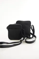 Morral bandolera de cuero genuino color marrón, con diseño compacto, cierre superior y correa ajustable para el hombro.