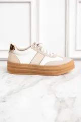 Zapatillas bajas de cuero color blanco y beige con suela marrón y detalle animal print en el talón.