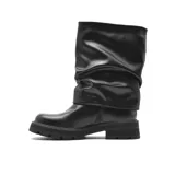 Bota de caña media con diseño 2 en 1, confeccionada en cuero sintético negro. Presenta una caña holgada con efecto arrugado y una suela track robusta de goma.