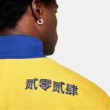 Chaqueta deportiva Nike del F.C. Barcelona, con cierre frontal completo y cuello alto. Diseño color azul con bloques en rojo y amarillo en las mangas, e incluye el logo de Nike y el escudo del club bordados.