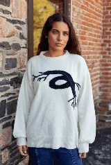 Sweater de punto color blanco con diseño de raíces en color azul marino en el frente, de corte holgado, cuello redondo y mangas largas con puños ajustados.