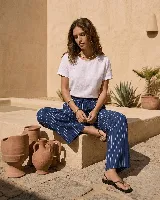 Pantalón ancho de lino azul marino con rayas verticales blancas, de corte holgado y cintura elástica con cordón ajustable. Cuenta con bolsillos laterales.