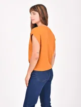 Remera de algodón color naranja, de corte holgado con mangas cortas con dobladillo y cuello redondo.