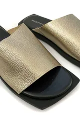 Sandalias doradas de cuero, con base plana negra.