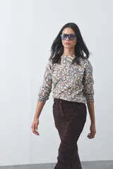 Sweater de punto con diseño de estampado animal print abstracto en tonos tierra y azul claro. Presenta cuello redondo a la base, mangas largas levemente amplias y terminaciones acanaladas en puños y ruedo.