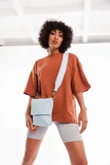 Bandolera azul de cuero vacuno con correa trenzada hecha a mano, forro interior y cierre con broche imán.