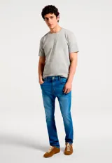 Pantalón vaquero de corte ajustado en color azul medio, con diseño clásico de cinco bolsillos, cierre de botón y cremallera.