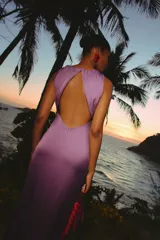 Vestido largo violeta Lady Pipa con escote drapeado, sin mangas, detalle de lazo cruzado en la cintura y tajo lateral en la falda.