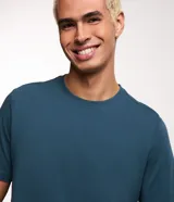 Remera básica de corte regular para hombre, color azul, confeccionada en algodón sostenible, con mangas cortas y cuello redondo.
