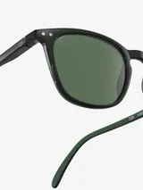 Lentes de sol Izipizi modelo #E, de forma trapezoidal, color negro con cristales verdes y patillas flexibles.